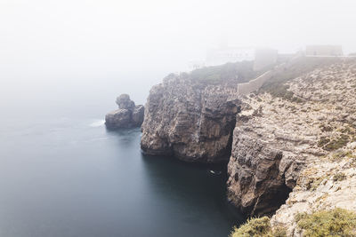 Rock formations by sea against sky