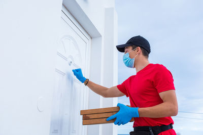 Side view of man working against wall