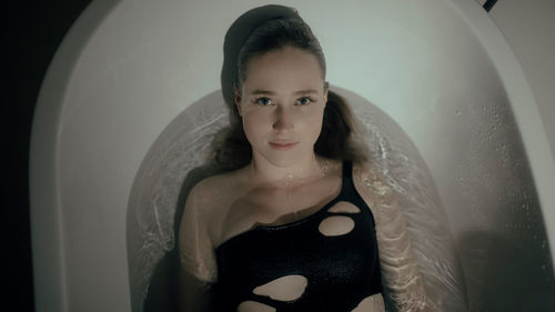 Portrait of young woman in bathtub