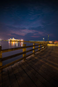 Pier over sea against sky at night