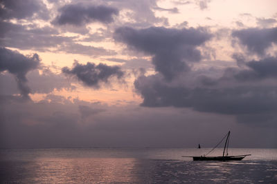 Sailboat sailing on sea against sky during sunset