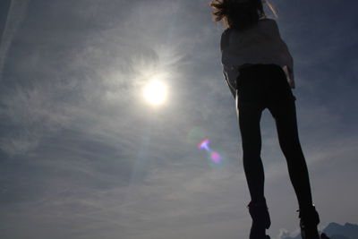 Low angle view of silhouette woman standing against bright sun