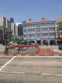 Vehicles on road against buildings in city