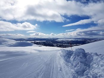 Snow covered landscape against sky