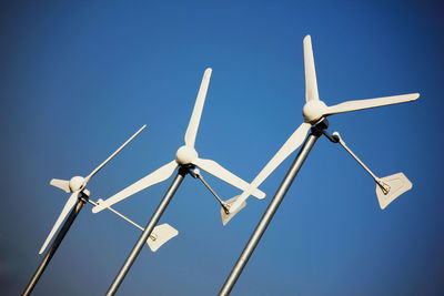 Low angle view of windmill against clear blue sky