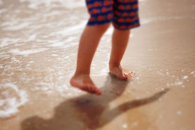 Low section of boy standing in water