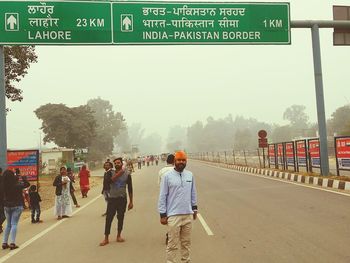 People walking on road along trees