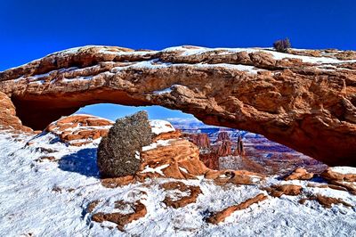 Rock formations against clear blue sky during winter