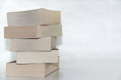 Close-up of stacked books against white background