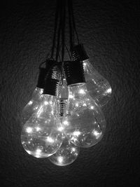 Close-up of illuminated light bulbs hanging from ceiling