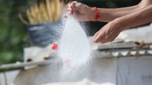 Cropped hands exploding water bomb