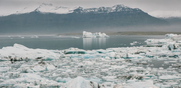 Scenic view of frozen sea against mountain