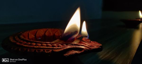 Close-up of lit candle in the dark