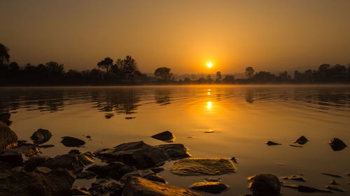 Scenic view of lake against sky during sunset