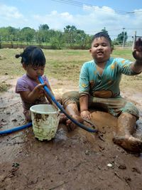 Full length of children sitting on land