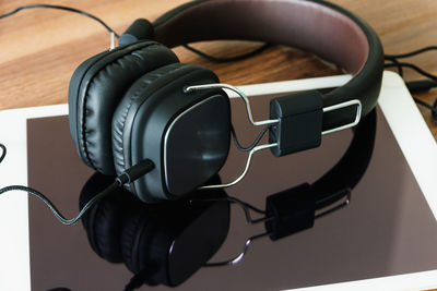 Close-up of headphones and digital tablet on table
