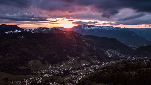 Scenic view of mountains against dramatic sky during sunset