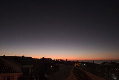 Silhouette buildings against sky at night