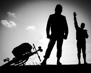 Low angle view of silhouette people against sky at sunset