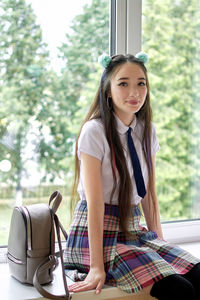 High school student is sitting on the windowsill. anime style