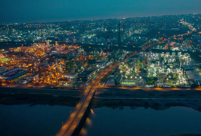 High angle view of illuminated city by river at night