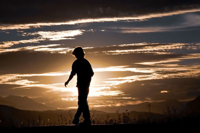 Silhouette man standing against sky during sunset