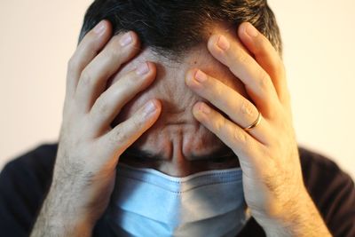 Close-up portrait of a man covering face