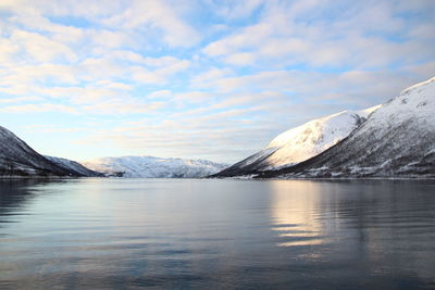 Scenic view of lake and snowcapped mountains against sky