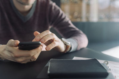 Midsection of man using mobile phone