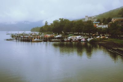 Scenic view of lake and buildings against sky