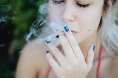 Close-up of woman smoking marijuana joint