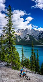 High angle view of woman mountain biking by lake minnewanka at banff national park