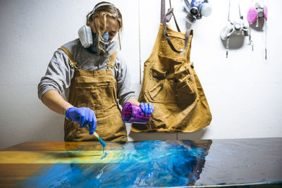 Female resin artist using simple tools to mix resin tint