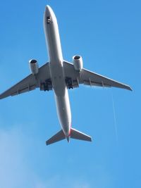 Low angle view of airplane against clear blue sky