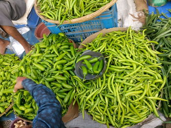 High angle view of man buying vegetables from market stall