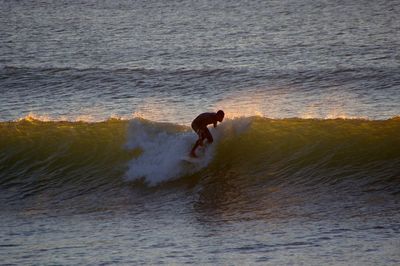 Full length of man surfing on sea shore