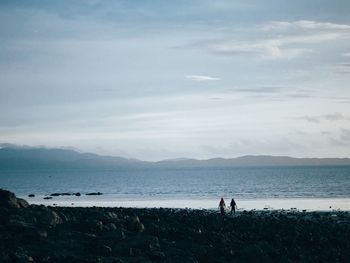 People on beach against sky