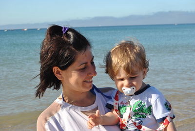 Smiling mother with son on beach