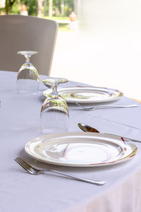 High angle view of empty plate with wineglasses on table