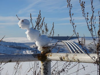 View of snow on wooden post against sky during winter