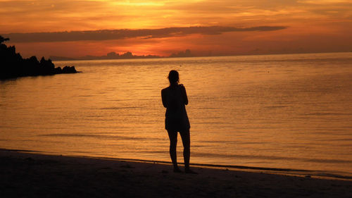 Silhouette of woman standing on beach