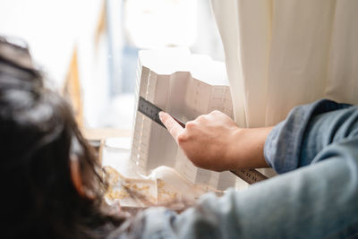 Close-up of woman measuring building model at home