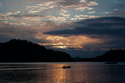 Boats in sea at sunset