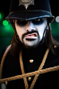 Close up portrait of male cosplayer in a scary british police uniform with white  face for halloween