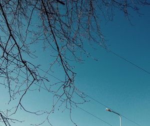 Low angle view of power lines against blue sky