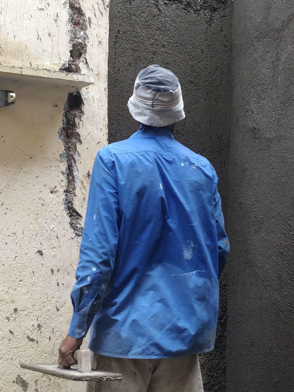 PORTRAIT OF A YOUNG MAN STANDING AGAINST WALL