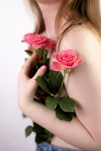 Midsection of woman holding flower against white background