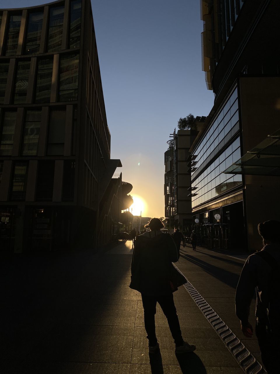 PEOPLE WALKING ON CITY STREET AGAINST SKY