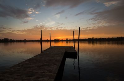 Jetty on lake against sky during sunset