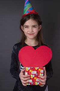 Portrait of smiling woman standing against wall